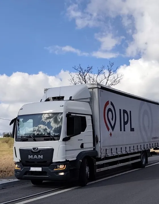 Ciężarówka MAN z naczepą plandekową IPL w trakcie transportu drogowego
