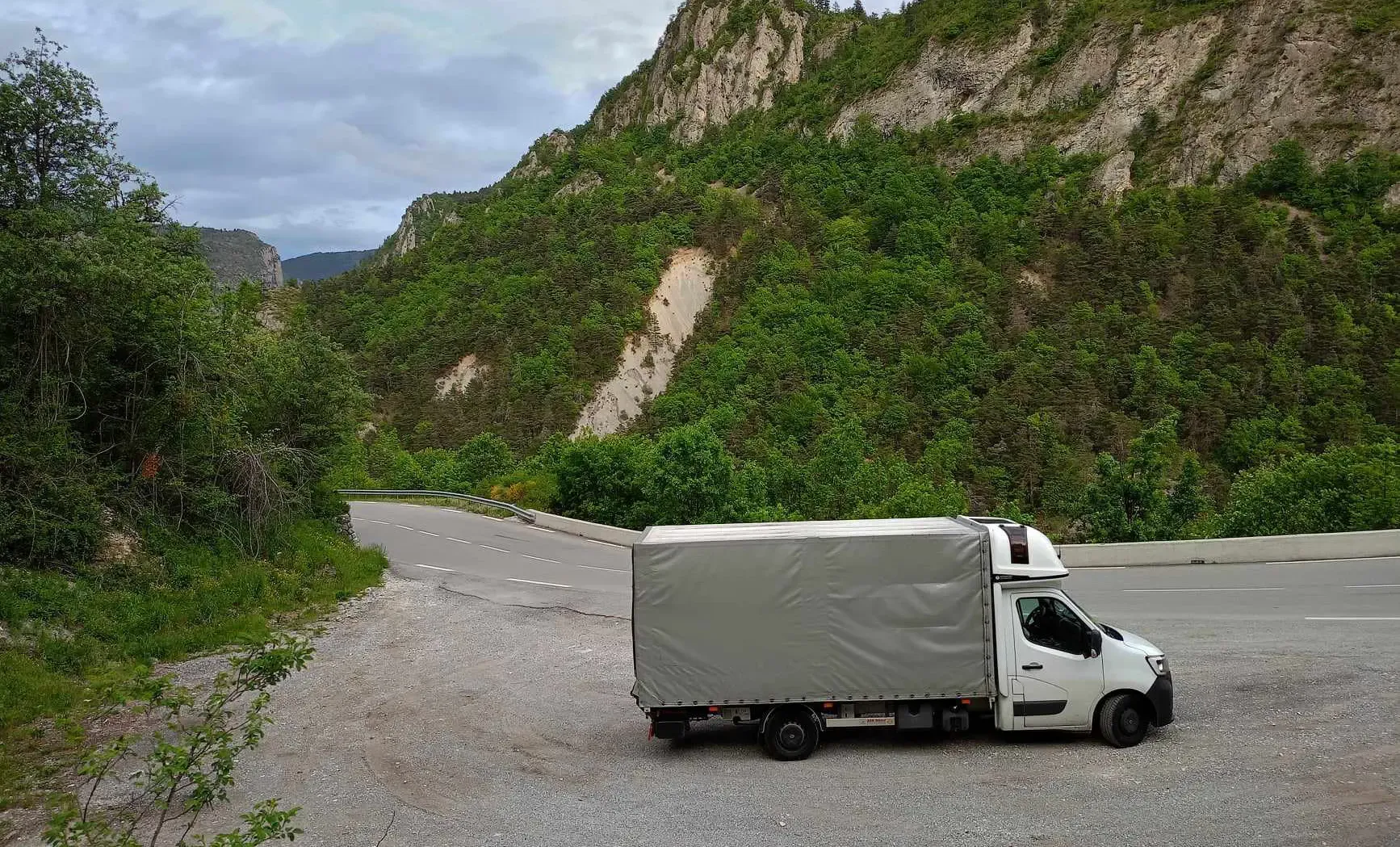 IPL-Lieferfahrzeug auf einer Bergstraße während eines internationalen Transports