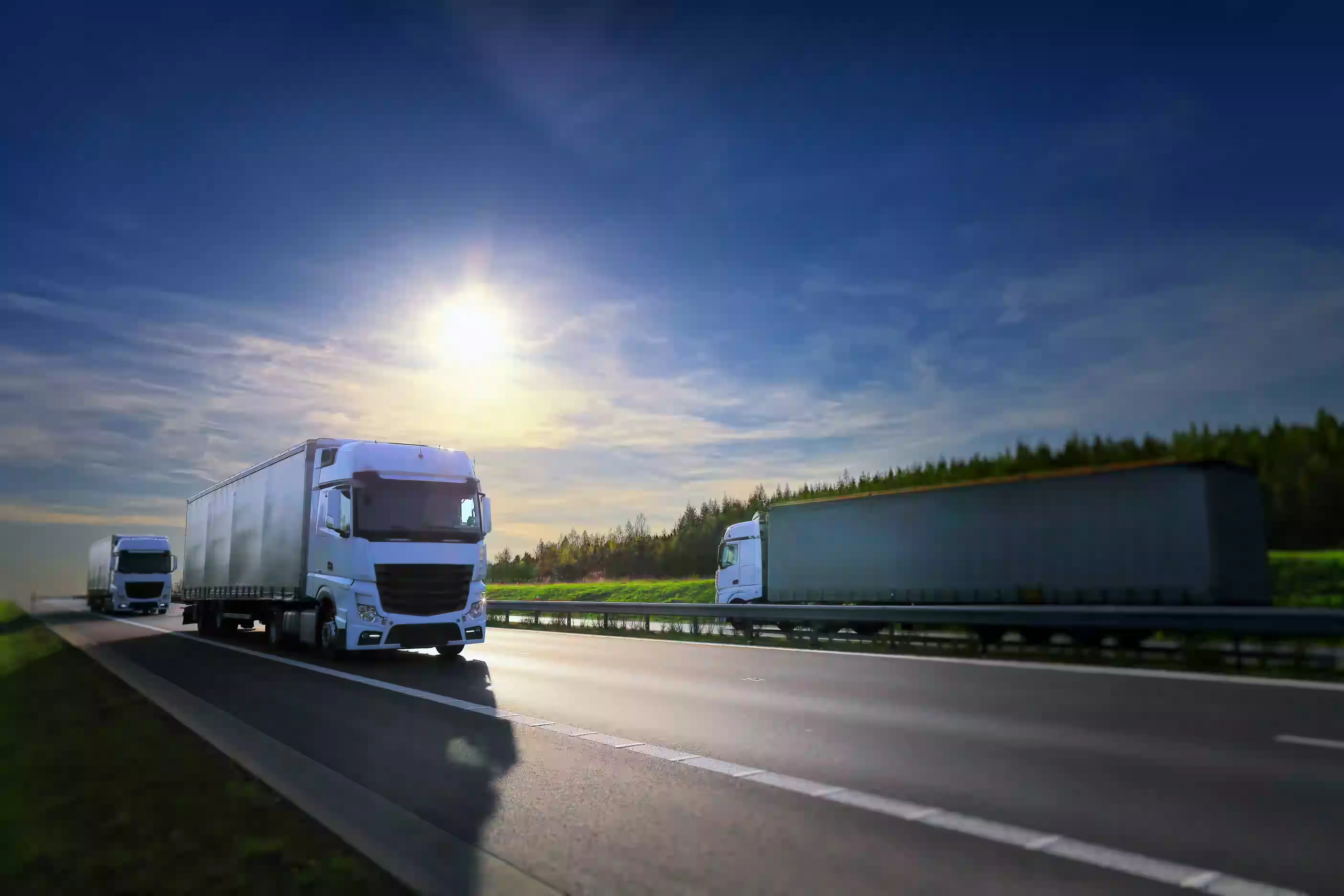 Ciągniki siodłowe z naczepami w trakcie realizacji zleceń transportowych na autostradzie.