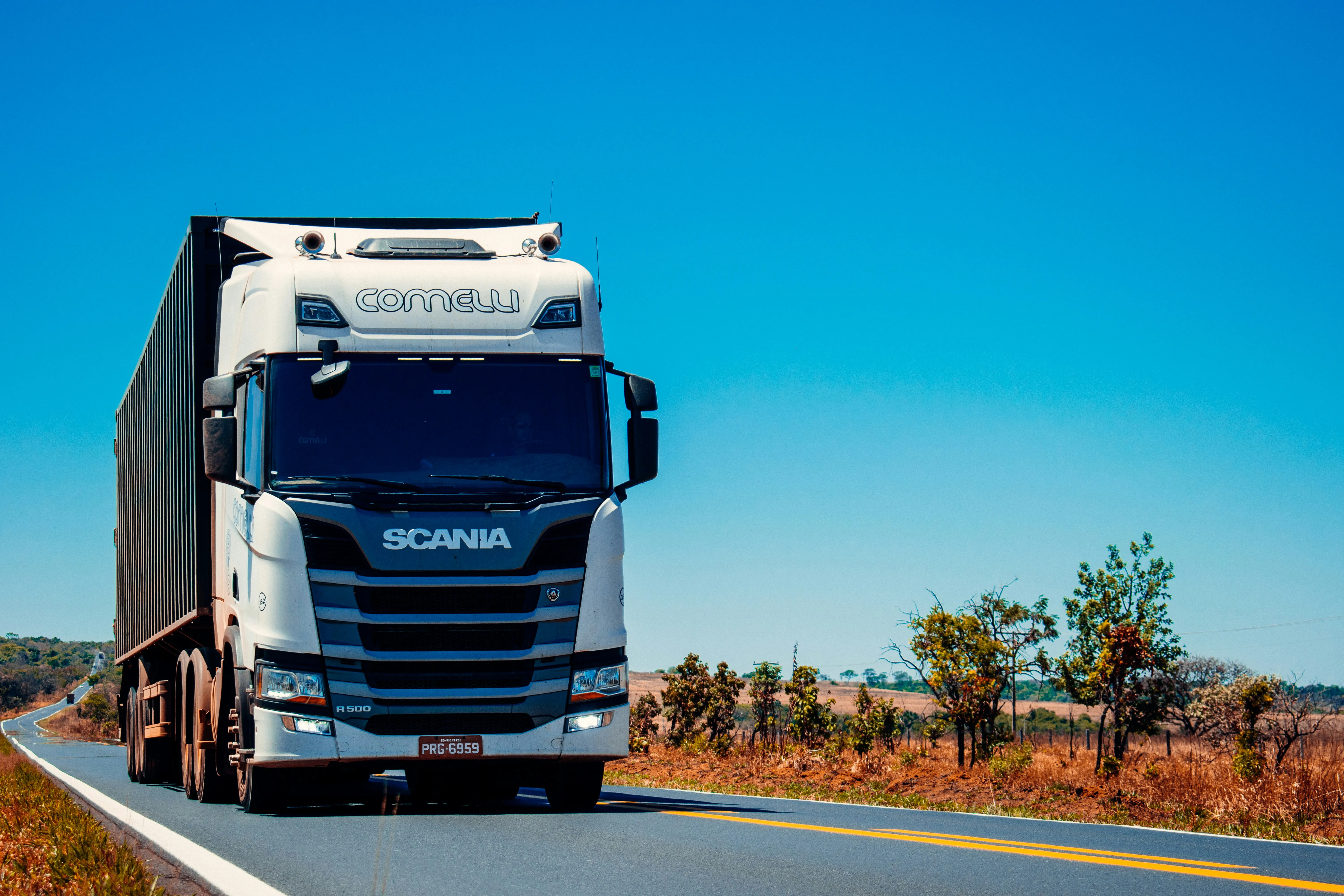 Duży ciągnik siodłowy Scania z naczepą w trakcie realizacji zlecenia transportowego.